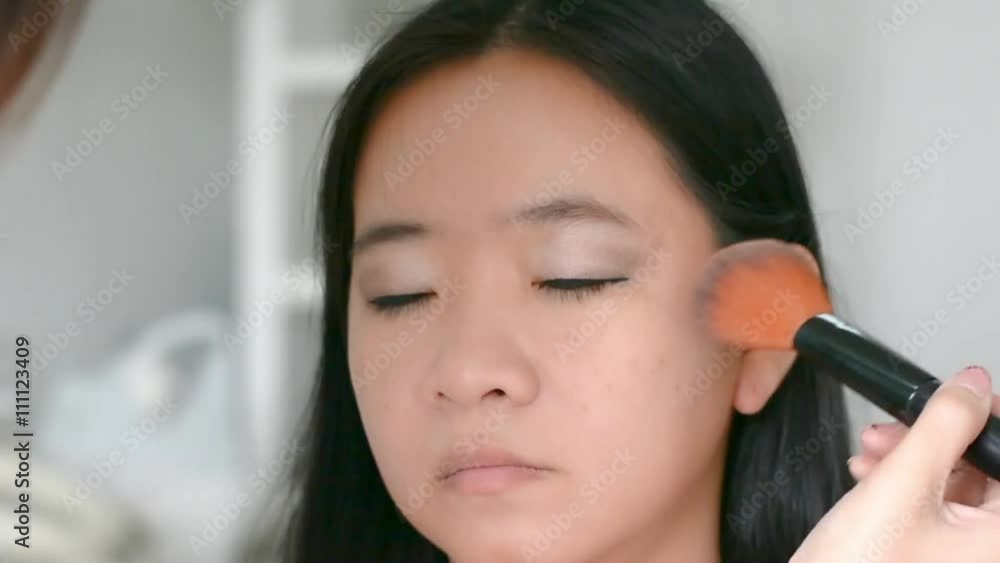 Woman is doing facial cosmetic makeup using face powder rouge brush to a model to create blush cheek in HD quality Woman is doing facial cosmetic makeup using face powder rouge brush to a model to create blush cheek in HD quality