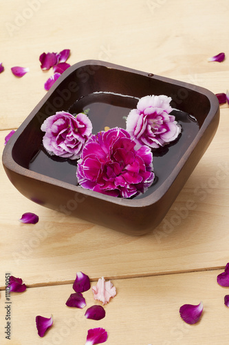 carnation flower in wooden bowl with water