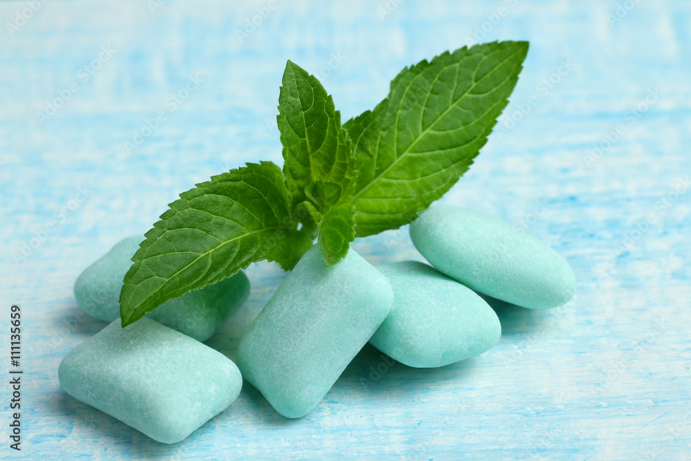 blue gum in the form of cushions on blue wooden background with mint leaves blue gum in the form of cushions on blue wooden background with mint leaves