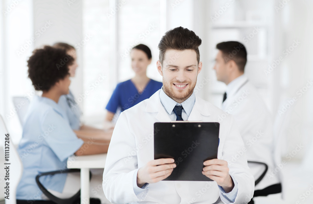 happy doctor with tablet pc over team at clinic happy doctor with tablet pc over team at clinic