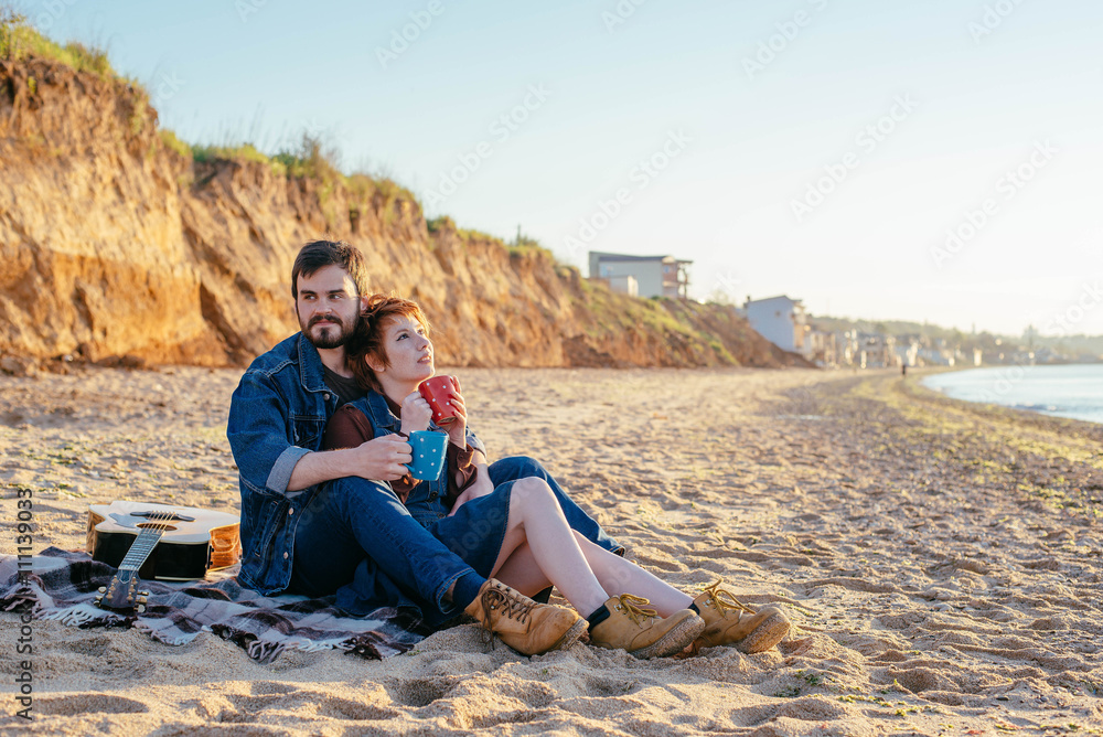 happy loving couple on beach, young man and woman enjoying sunset or sunrise on beach