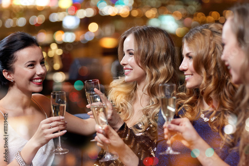 happy women with champagne glasses at night club
