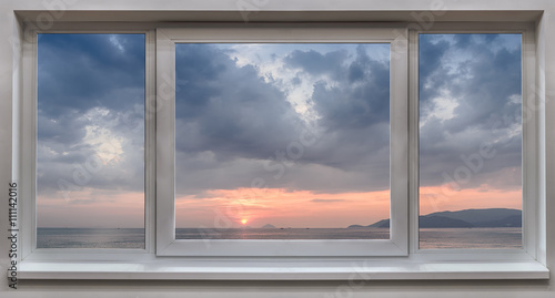 Fototapeta Okno z panoramicznym widokiem na morze i piękny wschód słońca