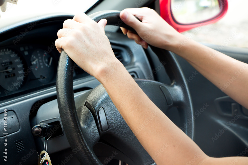 Male driver hands holding steering wheel of a car