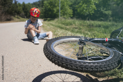 Boy is lying hurt after a bicycle accident. Kids safety concept