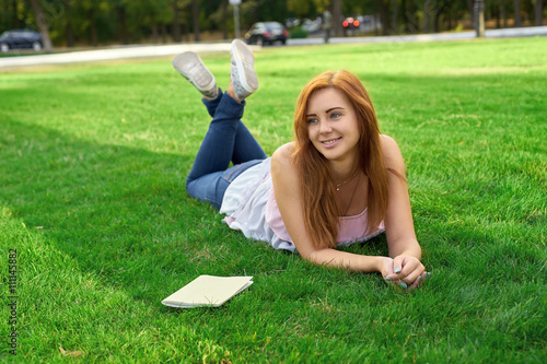 woman lying on a lawn with a diary