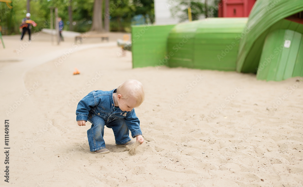 Child playing with sand in the playground Child playing with sand in the playground