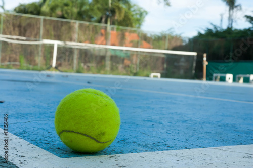 tennis ball on hard court background © lukmatulee