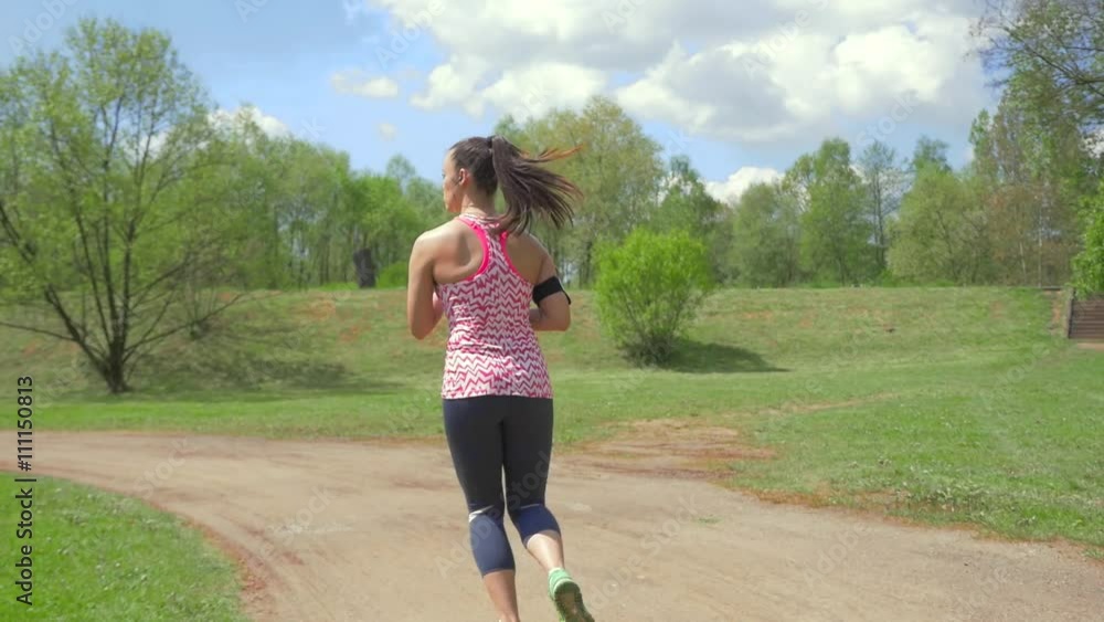 Girl drinking water and running in the park.
Girl drinking water and running in the park.