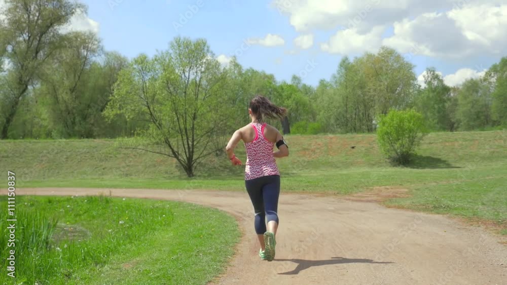 Girl drinking water and running in the park.
Girl drinking water and running in the park.