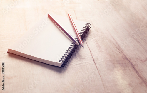 Notebook with pencil on wood background