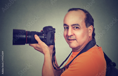 Side profile middle aged man using professional camera