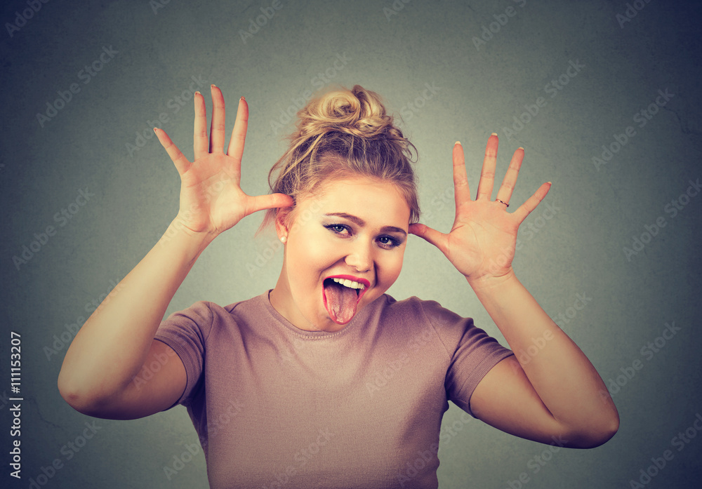 Young woman with funny face mocking someone making fun of something in a cruel way