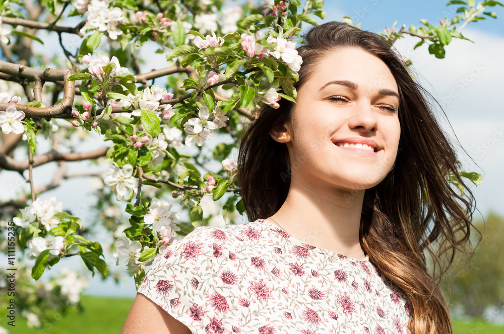 Portrait of beautiful smiling woman sitting in blooming garden Portrait of beautiful smiling woman sitting in blooming garden