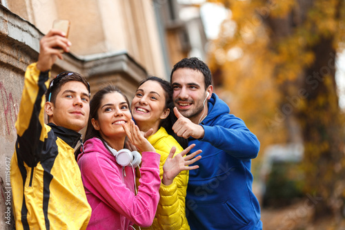 After their invigorating jog, the group pauses to catch their breath and captures a joyful moment with a cheerful selfie, celebrating the beautiful autumn day.