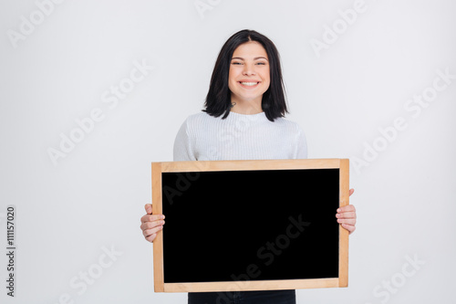 Beautiful young girl holding blank chalkboard