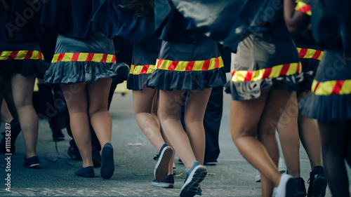 Back view of women's legs Carnival parade outdoors background. Dress uniform 