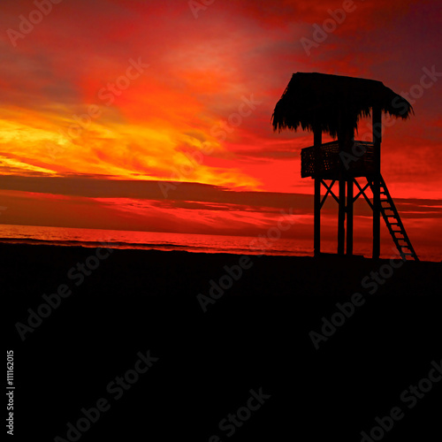 Resque watch tower on the Pacific Ocean beach in Ecuador during sunset.
