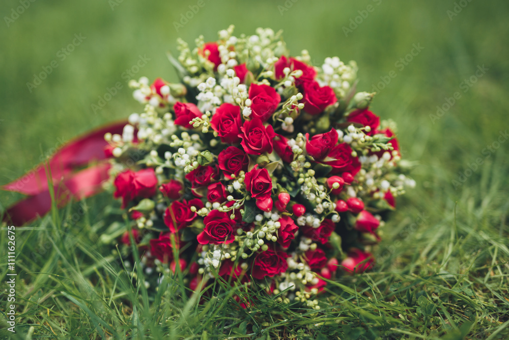 Bouquet of beautiful flowers and greenery is on the green grass