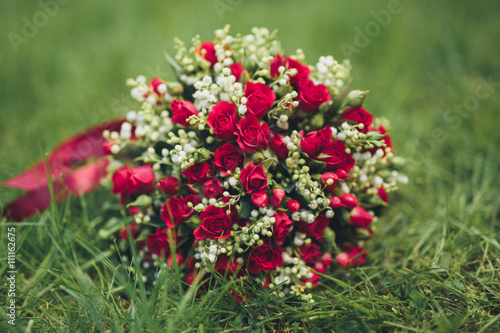 Bouquet of beautiful flowers and greenery is on the green grass