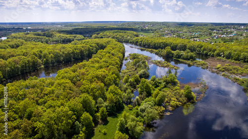 The top view on flood of the river, rural houses and forest, high water