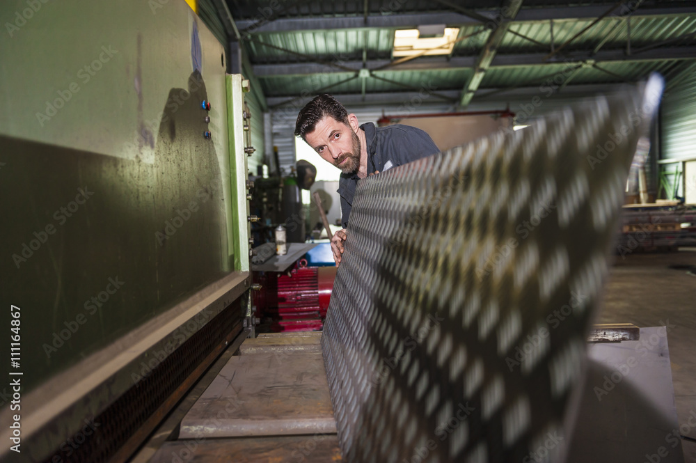 Man working, cutting machine, metal plate, in workshop Man working, cutting machine, metal plate, in workshop