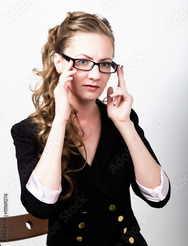 Successful business woman in a business suit one hand corrects glasses