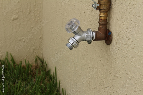 a water spigot on the side of a wall