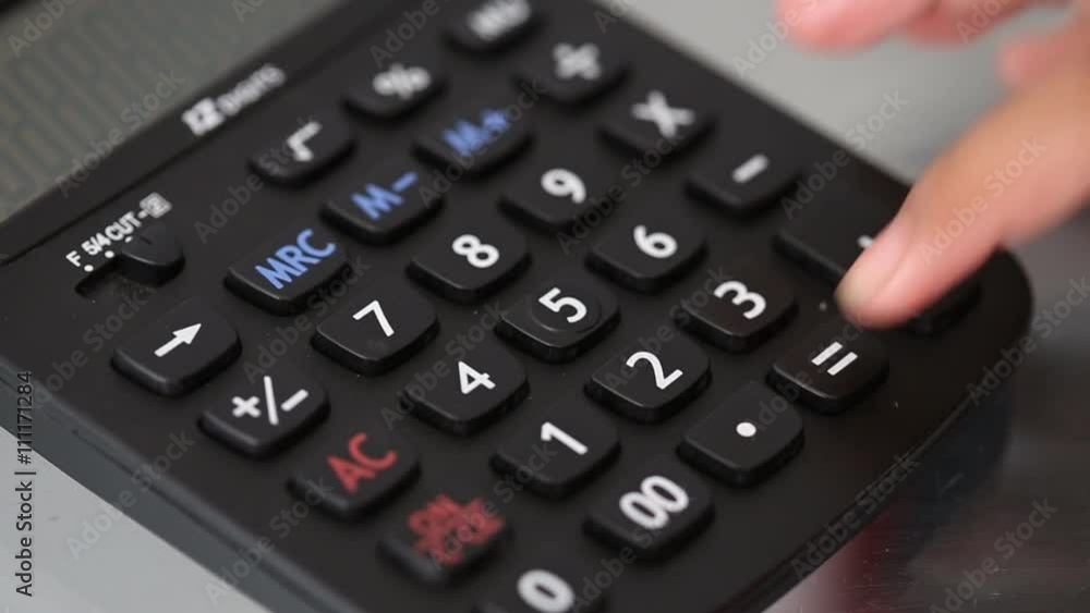 Hand pressing number on black calculator Hand pressing number on black calculator