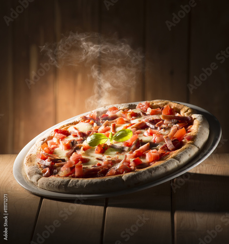 Pizza with bacon on the wooden table