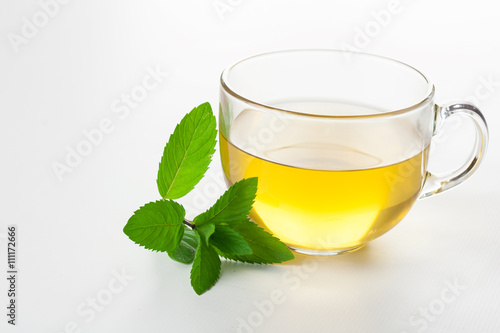 Glass of mint tea on white mint leaves on the side