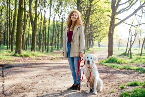 beautiful young girl walking with labrador dog in park 