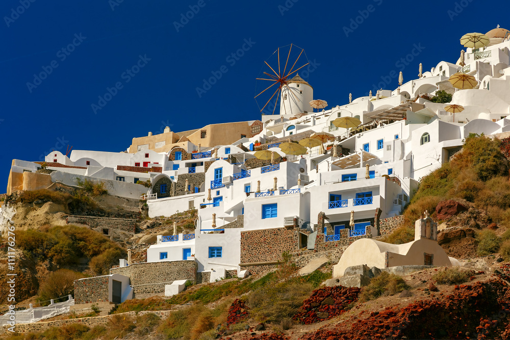 Windmills and white houses in Oia or Ia on the island Santorini, Greece