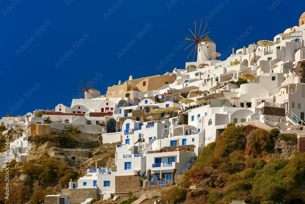 Windmills and white houses in Oia or Ia on the island Santorini, Greece