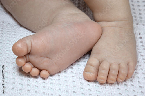 Newborn baby small legs on blanket, cute toes closeup