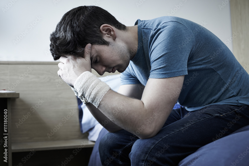 Depressed Young Man With Bandaged Wrists After Suicide Attempt Depressed Young Man With Bandaged Wrists After Suicide Attempt