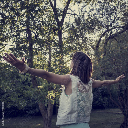 Woman standing in a park surrounded by trees