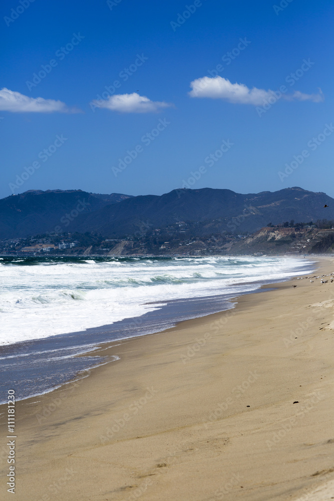 The waves of the Pacific ocean, the beach landscape. The ocean, mountains and blue sky in USA, Santa Monica. 
