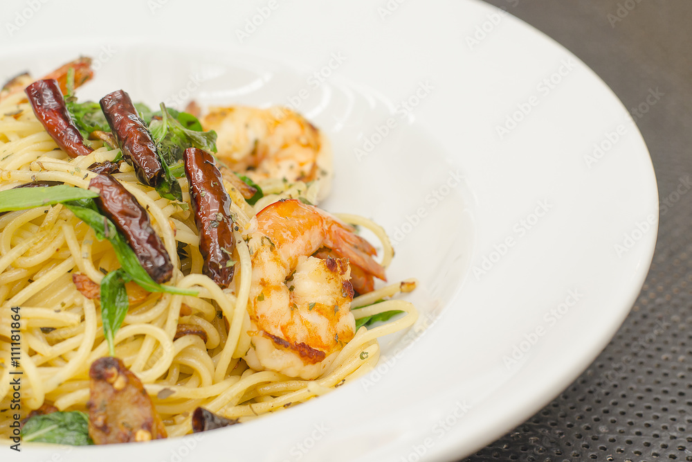 Tasty spicy spaghetti with shrimp on white plate