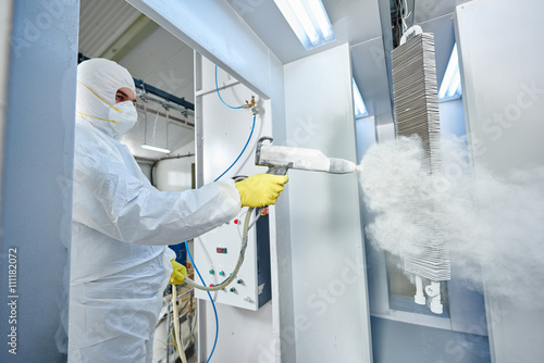 Fotografi industrial metal coating. Man in protective suit, wearing a gas