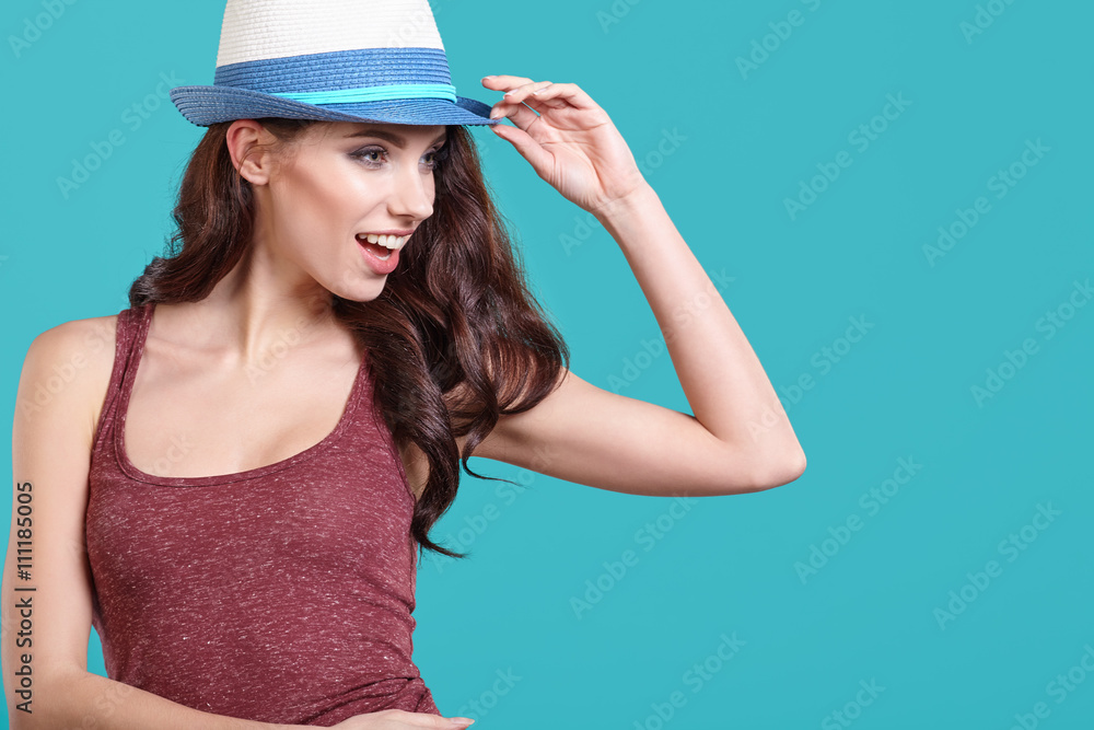 Young Woman with spring hat against blue background Young Woman with spring hat against blue background