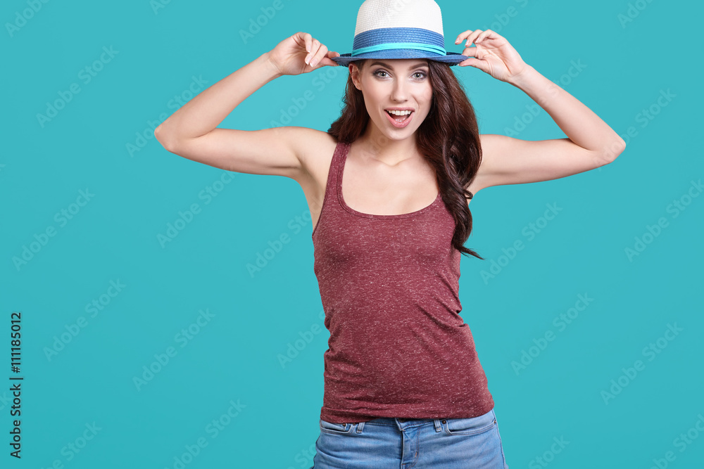 Young Woman with spring hat against blue background Young Woman with spring hat against blue background