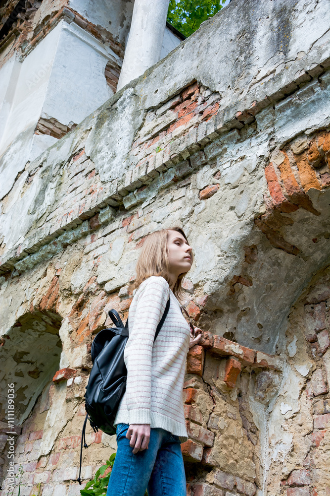 Girl standing near the destroyed wall in a park
