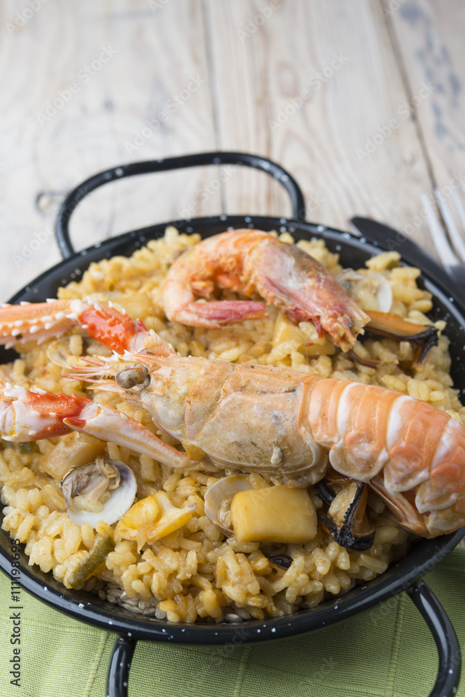 Vegetable paella with seafood on a wooden background Vegetable paella with seafood on a wooden background
