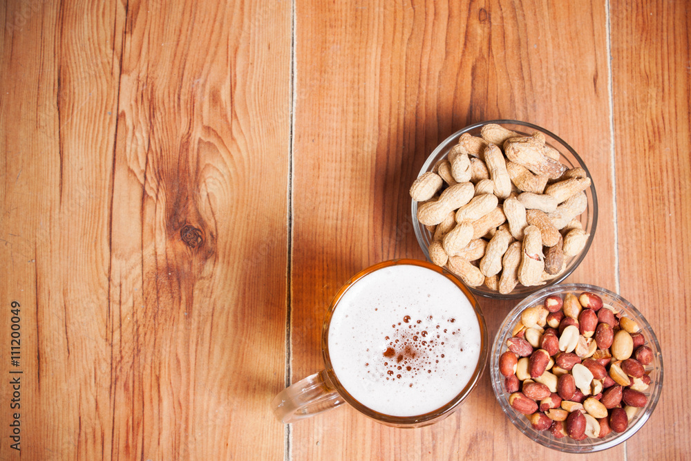 Beer background. Beer with peanuts on the brown wooden table. Fr