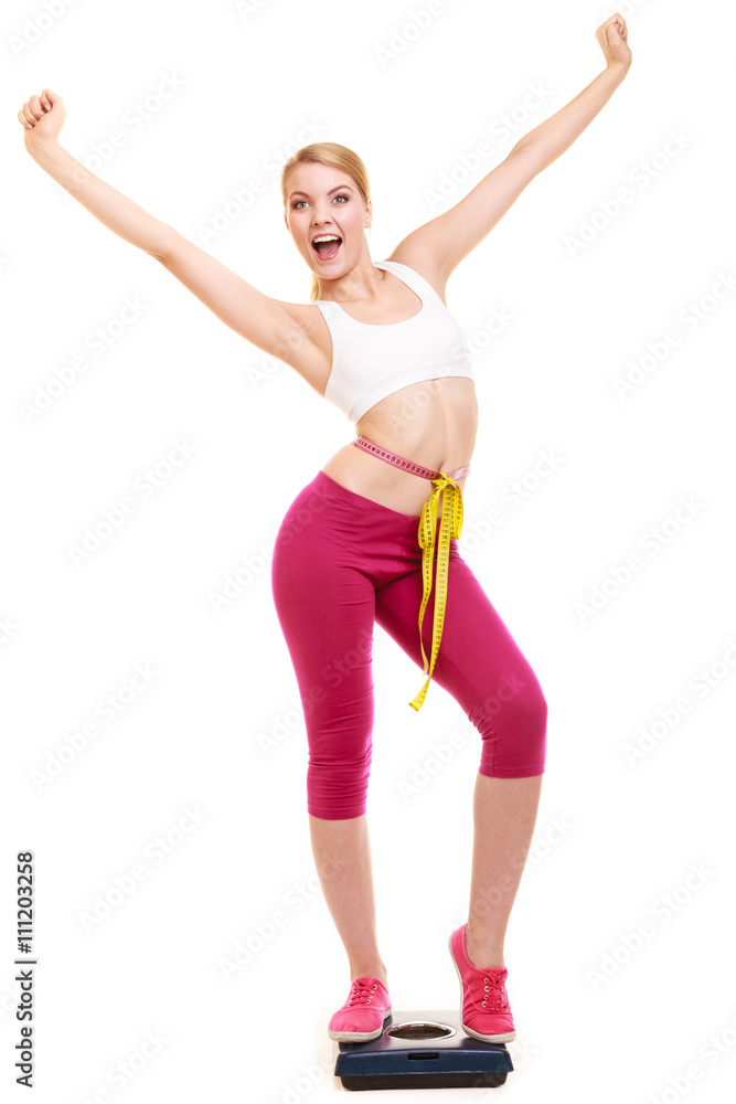 Woman measuring on weighing scale with raised arms Woman measuring on weighing scale with raised arms
