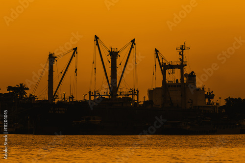 Sunset over dock ship or harbor near river