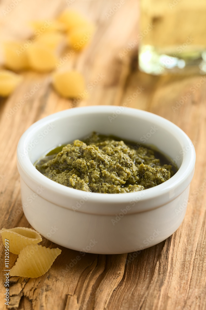 Pesto alla Genovese zubereitet aus Basilikum, Pinienkerne, Olivenöl und Knoblauch in kleiner Schüssel, fotografiert mit natürlichem Licht (Selektiver Fokus, Fokus ein Drittel in das Pesto) Pesto alla Genovese zubereitet aus Basilikum, Pinienkerne, Olivenöl und Knoblauch in kleiner Schüssel, fotografiert mit natürlichem Licht (Selektiver Fokus, Fokus ein Drittel in das Pesto)