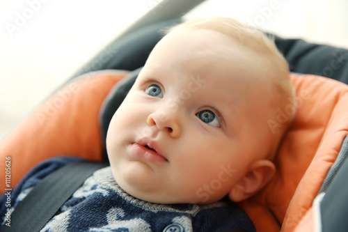 Adorable baby boy sitting i...
