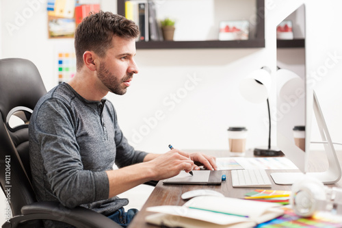 Male graphic designer busy at work